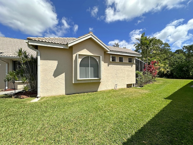 573 SW Saint Kitts St, Port Saint Lucie, FL 34953 - view of home's exterior featuring a yard, stucco siding, and a tiled roof