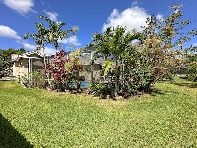 573 SW Saint Kitts St, Port Saint Lucie, FL 34953 - view of green lawn with an outdoor pool and glass enclosure