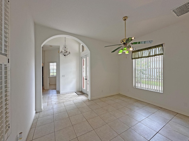 573 SW Saint Kitts St, Port Saint Lucie, FL 34953 - empty room with a ceiling fan, arched walkways, a chandelier, and light tile patterned floors