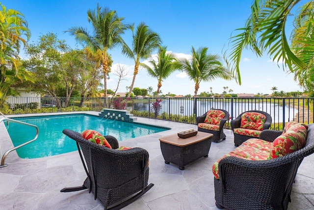 view of swimming pool with a fenced backyard, a fenced in pool, a water view, a patio, and an outdoor hangout area