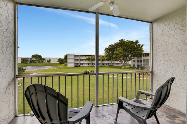 balcony with ceiling fan and a water view