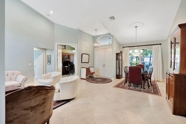 living room featuring visible vents, light tile patterned floors, high vaulted ceiling, baseboards, and a chandelier