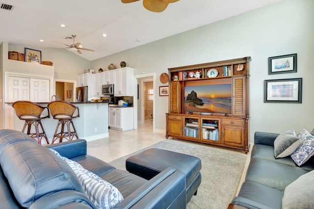 living area with ceiling fan, baseboards, light tile patterned floors, vaulted ceiling, and visible vents