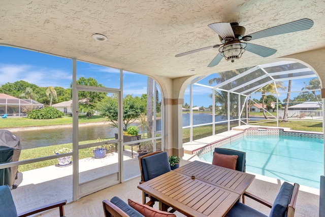 sunroom / solarium with a swimming pool, a water view, and ceiling fan
