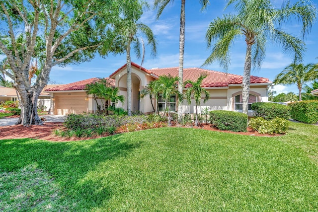 mediterranean / spanish house with stucco siding, a tiled roof, and a front yard