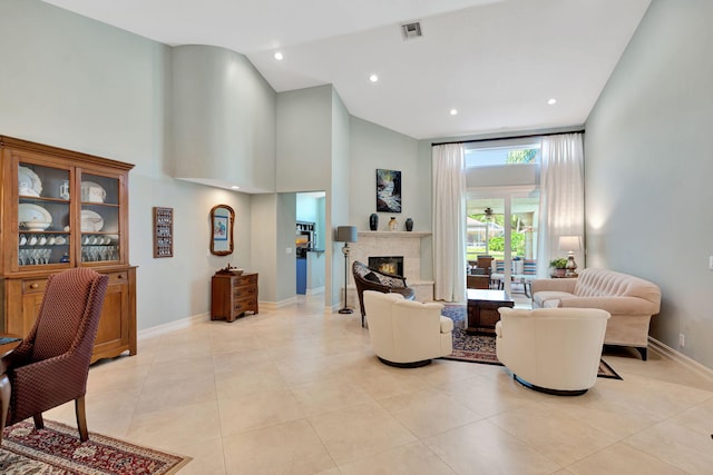 living room featuring visible vents, baseboards, high vaulted ceiling, and a premium fireplace