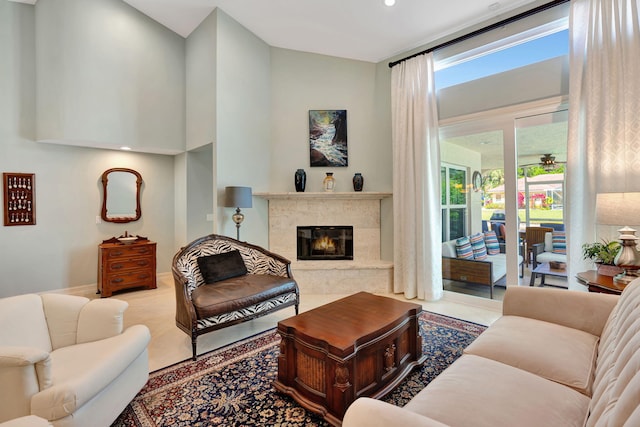 tiled living room with a towering ceiling, plenty of natural light, recessed lighting, and a premium fireplace