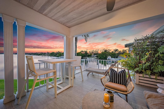 patio terrace at dusk with a water view and a balcony