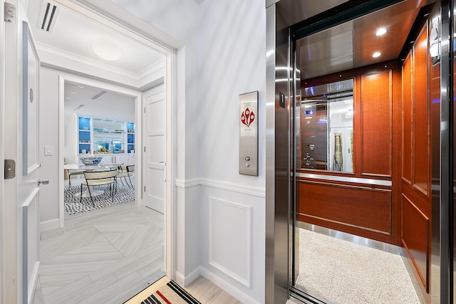 corridor featuring crown molding, visible vents, elevator, and baseboards