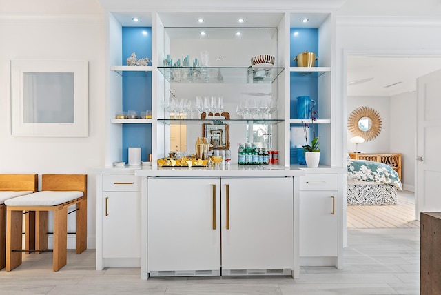 bar featuring fridge, built in features, and wet bar