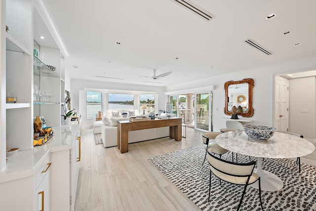 dining area with recessed lighting, ceiling fan, a water view, light wood-type flooring, and visible vents