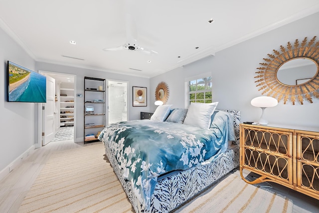 bedroom with connected bathroom, crown molding, ceiling fan, light wood-style floors, and baseboards