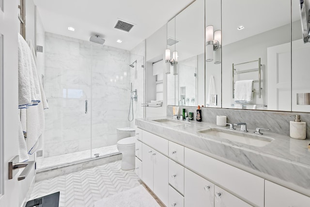 bathroom featuring double vanity, toilet, a sink, visible vents, and a stall shower