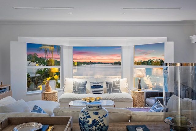 living room featuring crown molding and a water view