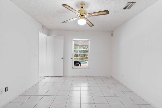 empty room featuring ceiling fan, a textured ceiling, and visible vents