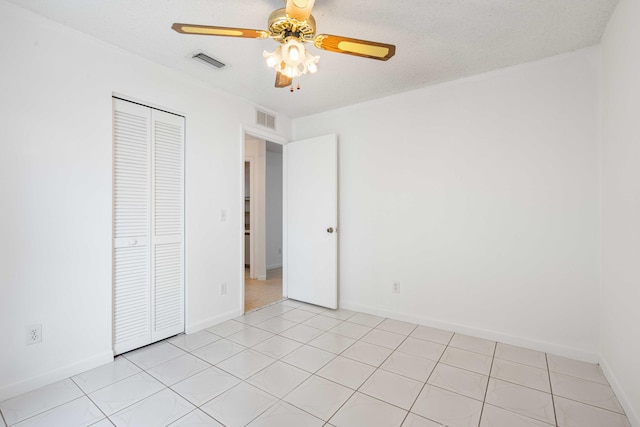 unfurnished bedroom with baseboards, a ceiling fan, a closet, and visible vents