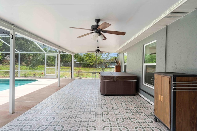view of patio / terrace with a hot tub, a ceiling fan, an outdoor pool, and glass enclosure