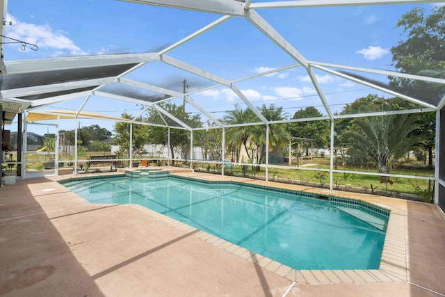 view of pool featuring a lanai, a pool with connected hot tub, and a patio area