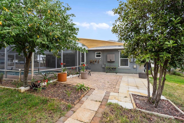 rear view of property featuring a patio, glass enclosure, an outdoor pool, and stucco siding