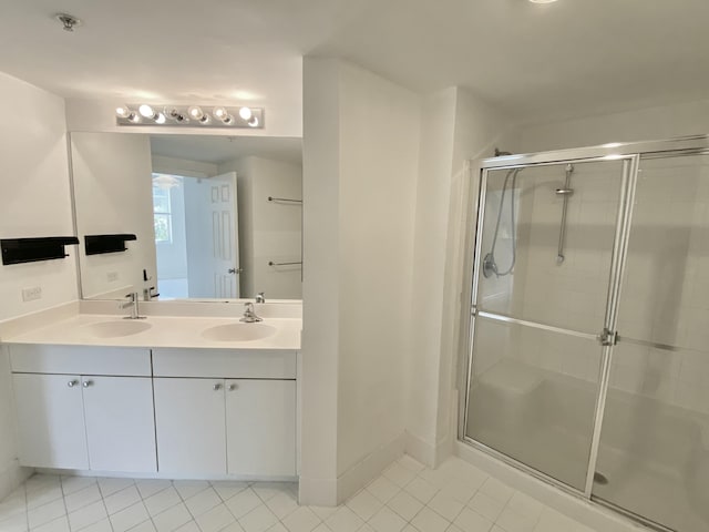 full bath with tile patterned flooring, a sink, a stall shower, and double vanity