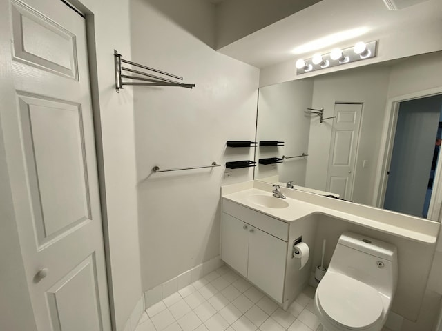 bathroom featuring baseboards, tile patterned floors, toilet, and vanity