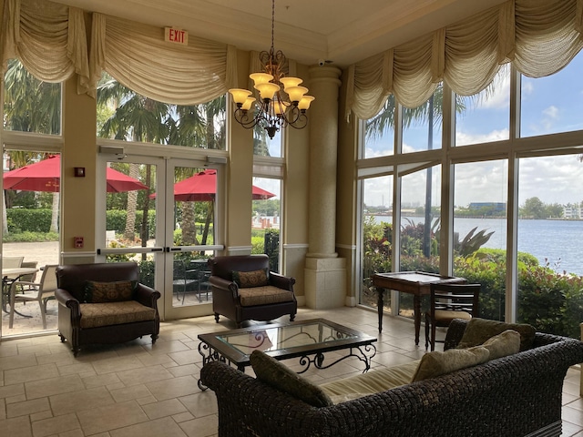 sunroom / solarium with an inviting chandelier, plenty of natural light, a water view, and french doors