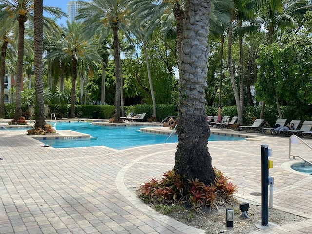community pool with a hot tub and a patio area
