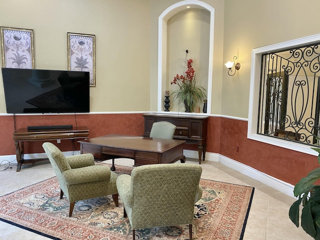 sitting room with tile patterned flooring, baseboards, and a wainscoted wall