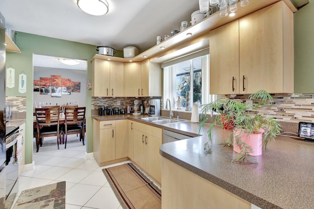 kitchen with light brown cabinetry, tasteful backsplash, electric range oven, a sink, and light tile patterned floors