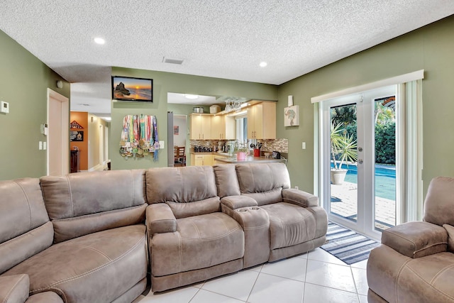 living room with light tile patterned flooring, recessed lighting, a textured ceiling, and visible vents