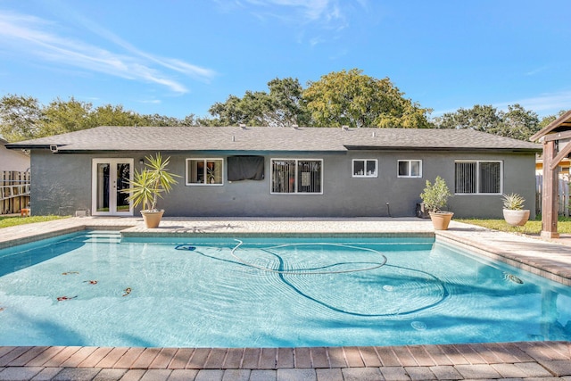 outdoor pool featuring fence and french doors
