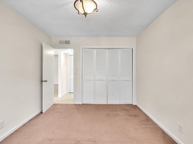 614 NW 13th St Unit 27, Boca Raton, FL 33486 - unfurnished bedroom featuring visible vents, carpet flooring, a textured ceiling, and a closet