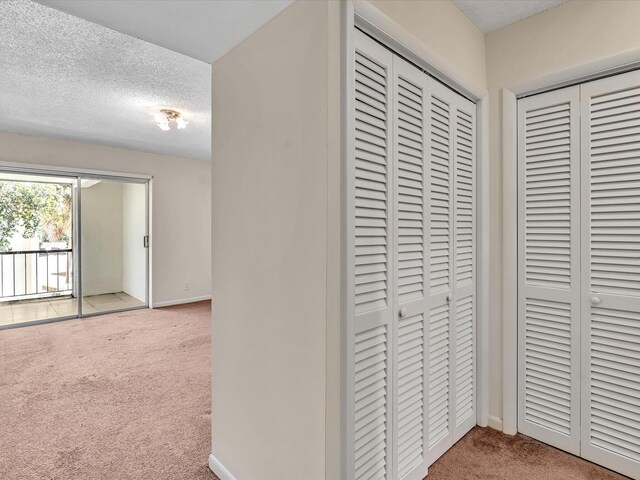 614 NW 13th St Unit 27, Boca Raton, FL 33486 - corridor with baseboards, carpet, and a textured ceiling