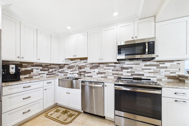 kitchen with a sink, light tile patterned floors, tasteful backsplash, and stainless steel appliances