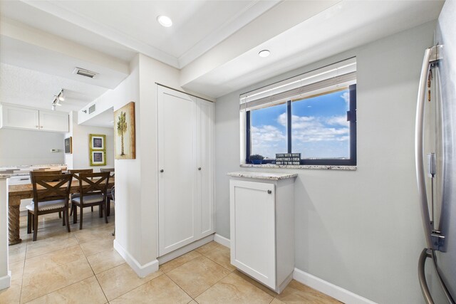 foyer featuring baseboards, visible vents, and light tile patterned floors