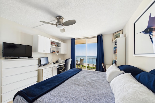 bedroom with a ceiling fan, a textured ceiling, access to exterior, built in desk, and carpet flooring