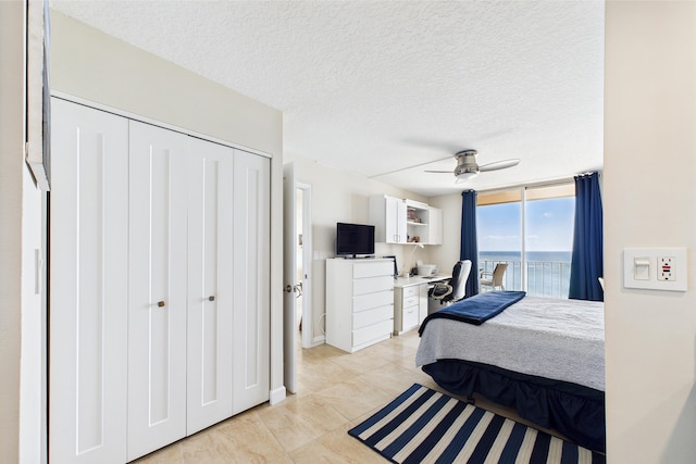 bedroom featuring light tile patterned flooring, ceiling fan, a textured ceiling, access to exterior, and a closet