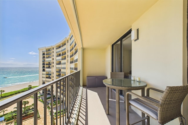 balcony featuring a beach view and a water view