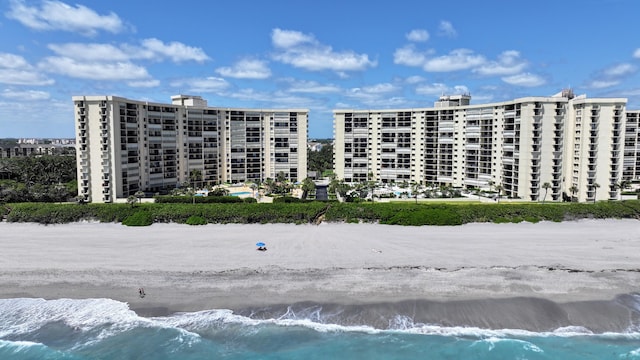 view of property with a beach view and a water view