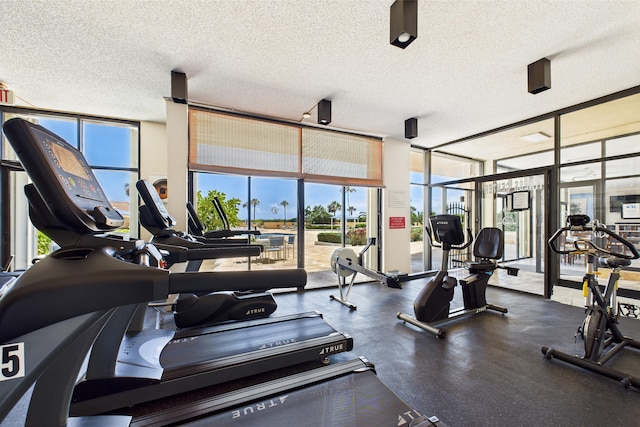 workout area with floor to ceiling windows and a textured ceiling