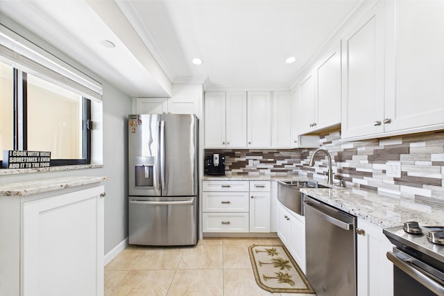 kitchen featuring backsplash, a sink, light tile patterned flooring, stainless steel appliances, and white cabinetry