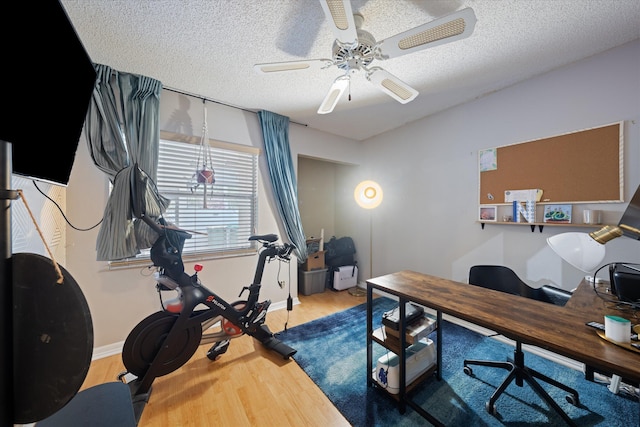 office featuring baseboards, wood finished floors, a ceiling fan, and a textured ceiling