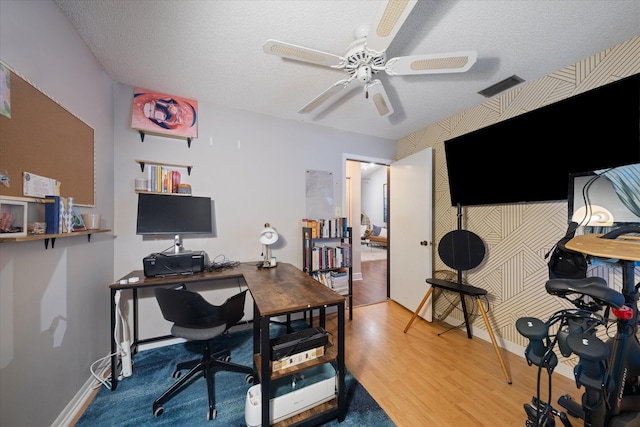 office area featuring a textured ceiling, wood finished floors, a ceiling fan, and visible vents