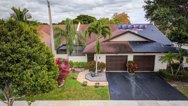 view of front of property with stucco siding, aphalt driveway, a shingled roof, and an attached garage