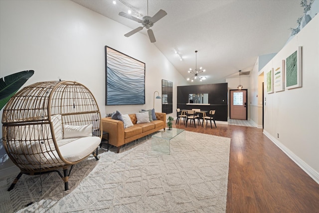living room with wood finished floors, high vaulted ceiling, ceiling fan with notable chandelier, and baseboards