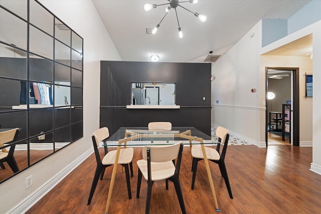 dining space featuring an inviting chandelier, wood finished floors, and baseboards