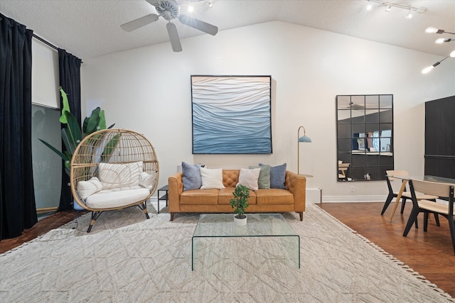 living area with lofted ceiling, a ceiling fan, baseboards, a textured ceiling, and wood finished floors