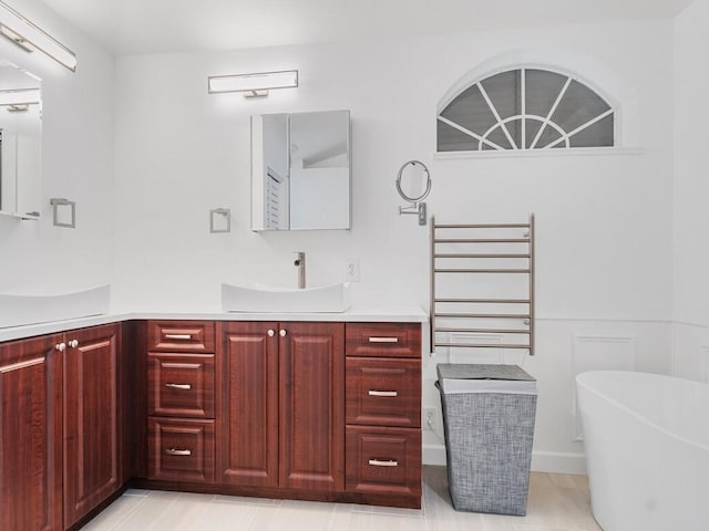 bathroom featuring a soaking tub and vanity