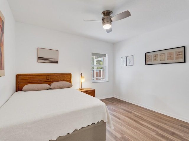 bedroom with baseboards, light wood finished floors, and ceiling fan