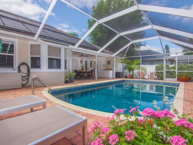 view of swimming pool with a patio, a ceiling fan, glass enclosure, and a fenced in pool